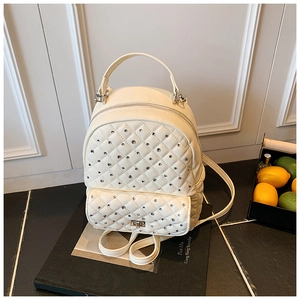 Dettaglio dello zaino mini crema con trapuntatura a rombi, strass e chiusura in metallo