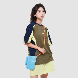 Blue mesh crossbody bag with orange paracord strap shown on model in urban style