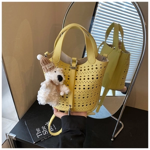 Détail du sac seau jaune ajouré avec découpes laser et charmant ours en peluche