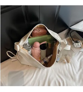 Vue intérieure montrant la grande capacité du sac fourre-tout blanc avec objets du quotidien