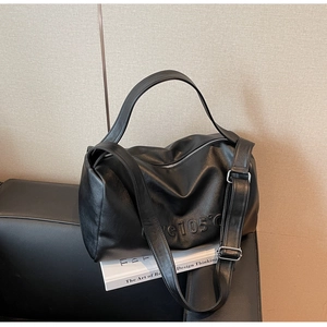 Close-up of matte lychee pattern black leather bag with embossed 105°C text and silver buckle