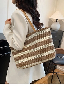 Bolso tote tejido a rayas marrones y beige con correas de cuero sobre modelo