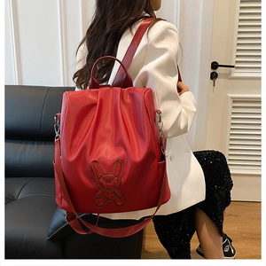 Detail of red faux leather backpack with bunny silhouette and adjustable straps