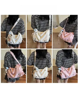 Détail du sac cabas dumpling avec appliques papillon et breloque peluche de chiot mignon