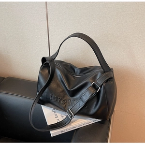 Detail of matte black leather Boston bag with embossed love 100 percent text and wide strap