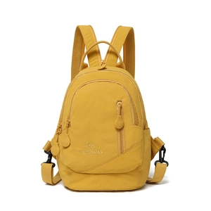 Detailed close-up of a yellow mini nylon backpack featuring the embroidered logo and zipper