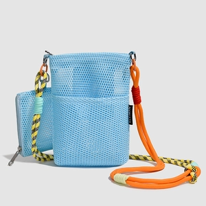 Detail of blue mesh crossbody bag with vibrant orange climbing rope strap and small pouch