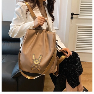 Detail of khaki fashion backpack with sequined rabbit patch on high-quality fabric