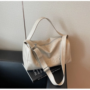 Detailed close-up of beige soft leather tote bag showing unique c105 debossed logo detail