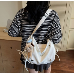 Détail du sac demi-lune blanc avec papillons argentés et pendentif chiot en peluche