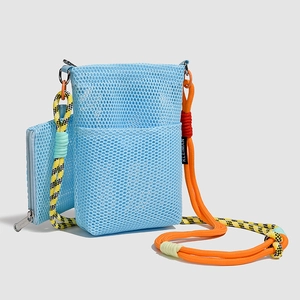 Detail of light blue mesh crossbody bag featuring colorful woven rope straps and zippers