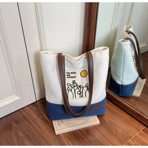 Detail of Moon and Sixpence canvas tote bag with denim patchwork and leather handles