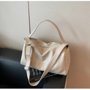 Close-up of beige tote bag with Love 105 embossing and smooth leather texture