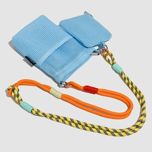 Detail of light blue mesh crossbody bag with multi-colored woven rope shoulder strap