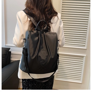 Close-up of the black leather backpack featuring a cute stitched rabbit outline detail