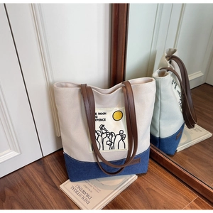 Detail of the canvas and denim patchwork tote bag with an artistic moon illustration