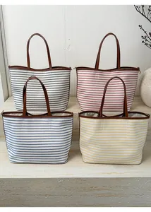 Detailed display of tote bags in four striped colors with premium brown leather handles