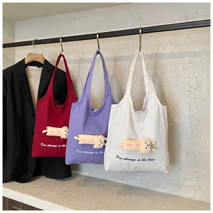 Detailed view of three canvas tote bags with cute 3D cat plush and artistic slogan