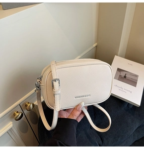 Détail du sac à main en cuir beige texture litchi avec boucle en métal argenté