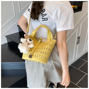 Détail du sac seau jaune ajouré au laser avec motifs creux et charmant petit chien