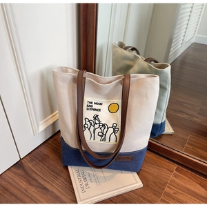 Detail of canvas tote bag with contrast stitching and Moon and Sixpence illustration