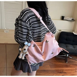 Détail du sac rose avec papillon métallique 3D et breloque chiot en peluche doux