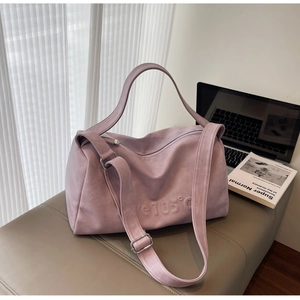 Macro shot of 105°C embossed texture on large mauve tote bag with metal zipper