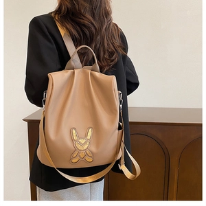 Detail showing faux leather backpack with gold sequin rabbit patch on model back