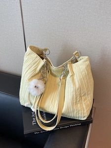 Borsa tote plissettata giallo tenue con catene d'argento e ciondolo di peluche bianco