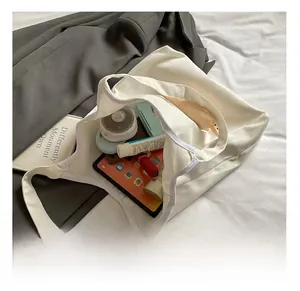 Interior view of the white canvas tote bag showing spacious capacity for daily items