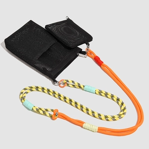 Detail of mesh crossbody bag with vibrant orange cord strap and small zipper pouch
