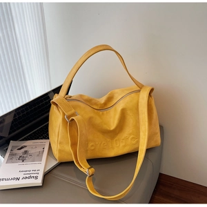 Detail of yellow boston bag with love 105 degree embossed text and matte texture
