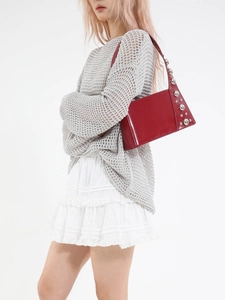 Red patent leather underarm bag with silver studs and metal balls for a vintage street look