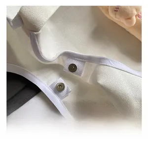 Close-up of durable metal snap fastener and high-quality canvas fabric on tote bag