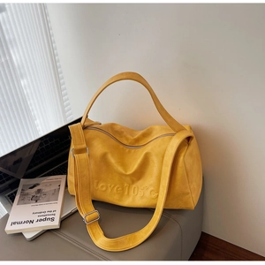 Detail of yellow tote bag with embossed Love 105°C lettering and matte leather texture