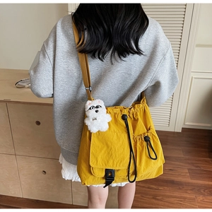 Detail of ginger crossbody bag featuring multi-pockets and cute plush puppy charm