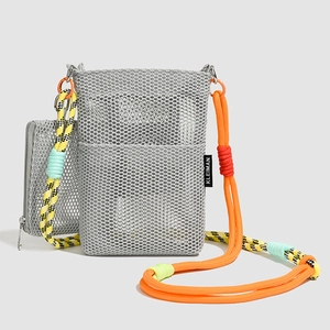 Detail of grey mesh crossbody bag with colorful woven rope strap and brand logo label