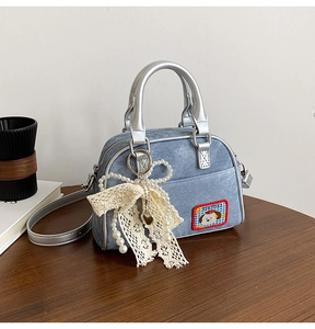 Détail du sac bowling en jean avec patch chien et grand pendentif nœud en dentelle perlée