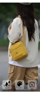 Détail d'un sac bandoulière en nylon jaune vif avec sangle large et logo métallique chic