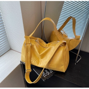 Detail of yellow leather barrel bag featuring love 103G embossing and silver hardware