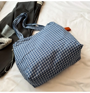 Detail view of blue and white checkered canvas tote bag with side drawstring feature
