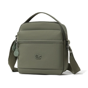 Détail macro du sac bandoulière en nylon vert olive montrant le logo et le zip frontal