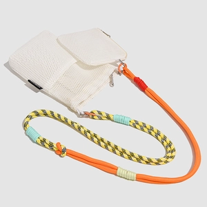 Detail of white mesh crossbody bag with colorful braided rope strap and metal zipper