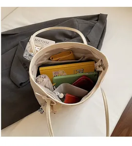 Spacious interior of cream tote bag showing pockets with books and accessories