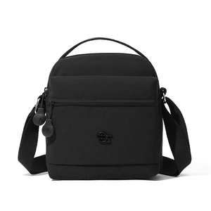 Gros plan sur un sac bandoulière noir en nylon avec poches zippées et poignée haut