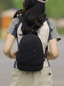 Modern black nylon multi-zipper backpack shown on model for outdoor leisure and travel