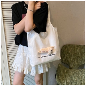 White canvas tote bag featuring a plush 3D cat doll and black artistic typography