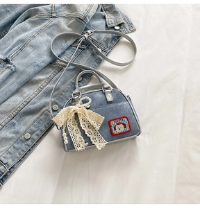 Détail du mini sac en jean avec broderie de chien et pendentif en dentelle et perles
