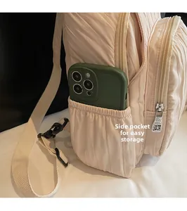 Detail of the side drawstring pocket on a quilted backpack for easy phone storage