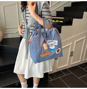 Detail of blue plaid canvas tote bag with cute cartoon embroidery for daily students